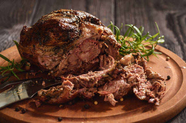Roasted lamb fillet on wooden background.