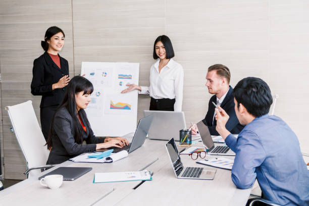 istock Businesspeople using laptops and discussing together in meeting room.Teamwork concept 914872620