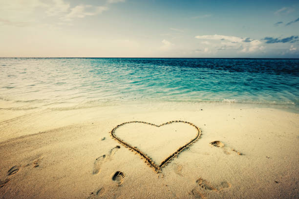 istock Heart shape drawn on a sand at the seaside. 914875044