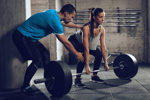 formazione con un personal trainer - crouching barbell weightlifting weight training foto e immagini stock