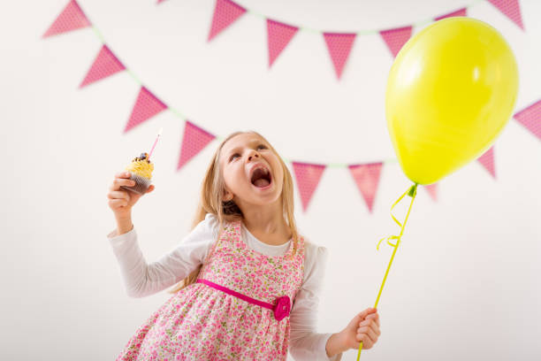 istock Little Girl With Balloon And Cupcake 914876372