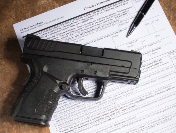 istock Handgun and paperwork foor a purchase 914876452
