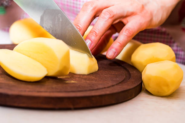 istock Female hands cut potatoes on wooden board 914876518