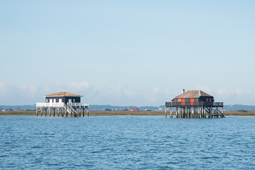 The world famous 'cabanes tchanquees' (huts on stilts), in front of the Island of Birds, on the Arcachon Bay
