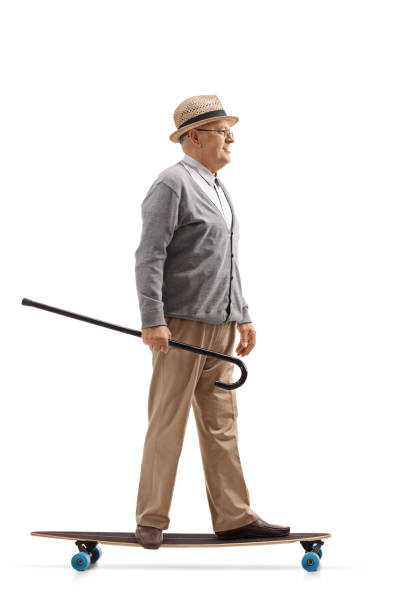 istock Mature man with a cane riding a longboard 914883224