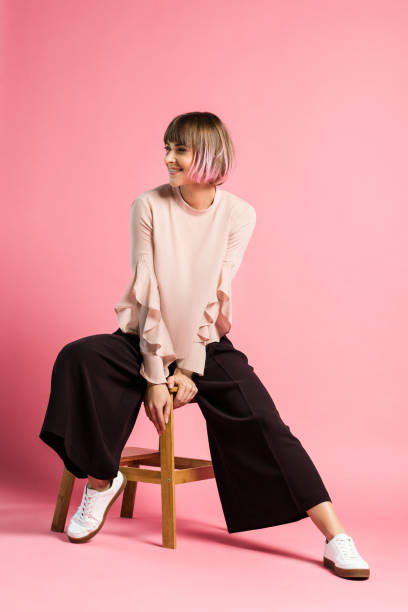 istock Smiling woman sitting on stool 914883348