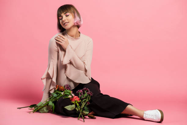 молодая женщина, сидящая на полу с букетом - sitting flower female studio shot стоковые фото и изображения