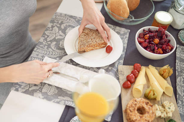 istock Woman slicing a healthy wholegrain bread roll 914886746