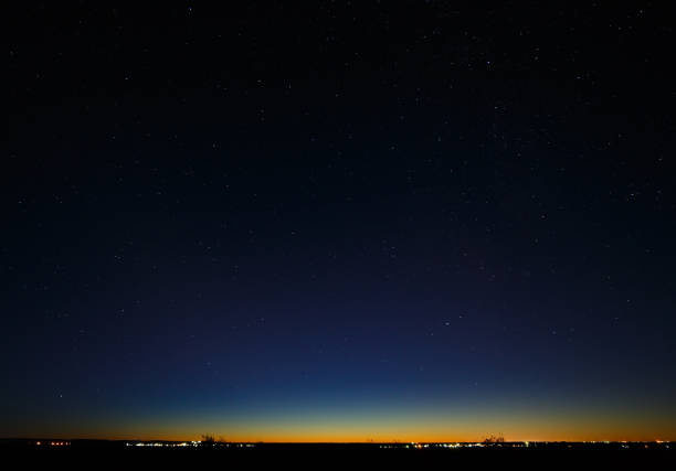 istock Night starry sky and city lighting on the horizon, after sunset. 914887318