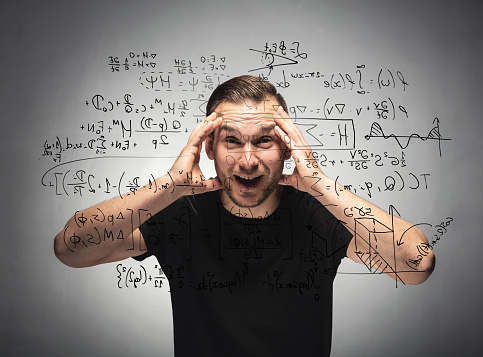 Shocked man looking at mathematical equation. Surprised and astonished man grabbing his head. Student concept.
