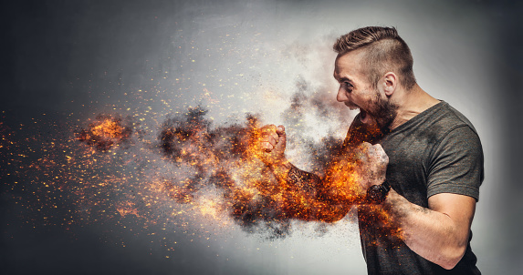 Excited man in fighting gesture with fists on fire. Rage concept. Heated fight. Aggressive behaviour concept