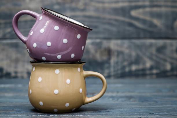 istock Yellow and Purple Ceramic Mug with White Dots on Blue Wooden Background 914891514