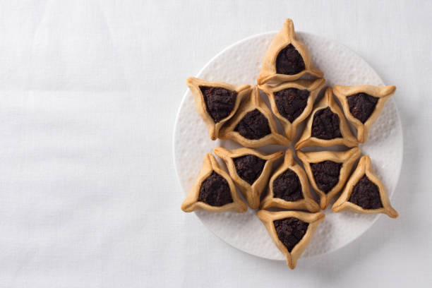 традиционные сладости для еврейского праздника пурим. печенье hamantashen или уши амана, треугольное печенье с маком - poppy seed стоковые фото и изображения