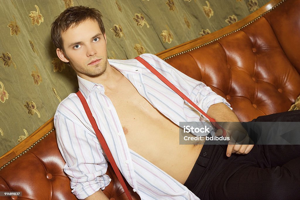 Sexy bel homme assis sur un canapé - Photo de Adulte d'âge mûr libre de droits