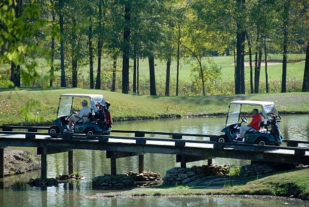 des voiturettes de golf sur le pont de creek - golf cart golf bag horizontal outdoors photos et images de collection