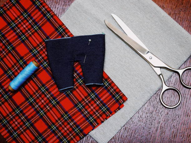 istock made by hand sewing small pants for a doll. Needlework. Handmade concept 914901946