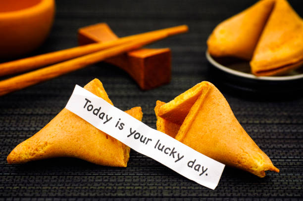 istock Paper strip with phrase Today is Your Lucky Day from fortune cookie, another cookie and chopsticks on black napkin background. 914909026