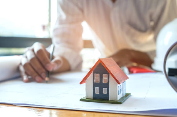 istock Architects are writing home plan,Model house on House plan. 914912554