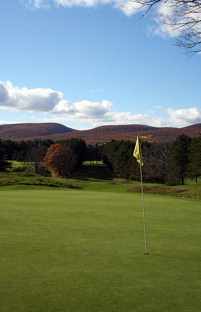 ゴルフコースのグリーン、秋の山々 - putting golf sports flag short game ストックフ�ォトと画像