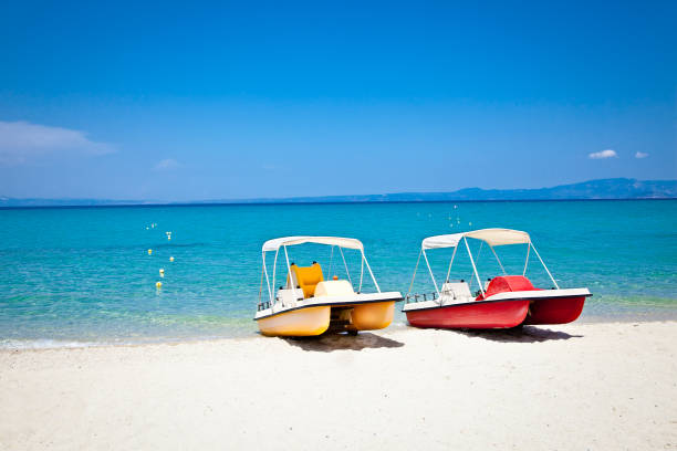 Beautiful Hanioti beach with Colorful pedalos docked on Kasandra peninsula, Halkidiki,  Greece.