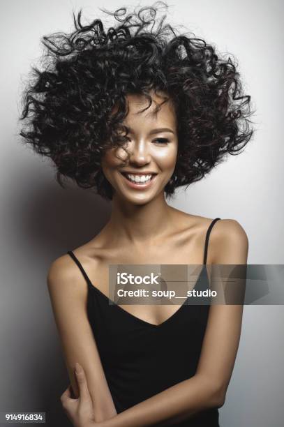 Smiling Woman In Black Dress With Afro Curls Hairstyle Stock Photo - Download Image Now