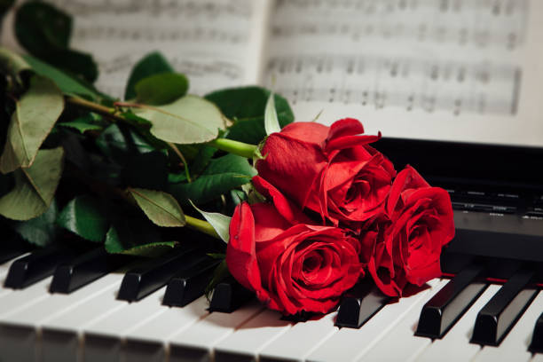 istock red roses on piano keys and music book 914932618