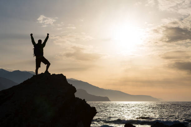 istock Man with arms outstretched celebrate mountains sunrise 914933034