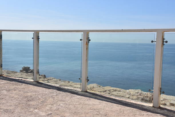Seascape in summer evening. Wooden fence on the embankment