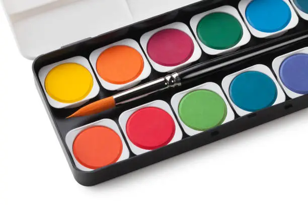 Photo of Watercolor paints set and brush on white background. Photo with clipping path.