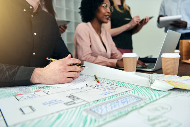 istock Designer working on blueprints with his team in an office 914934378