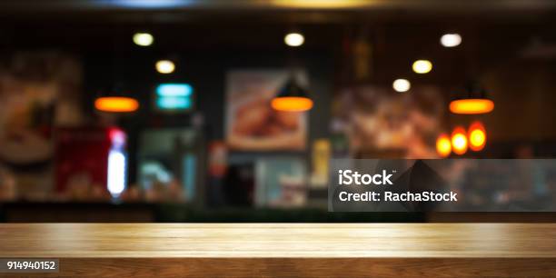 Empty Wooden Table Top With Blur Coffee Shop Or Restaurant Interior Background Panoramic Banner Stock Photo - Download Image Now