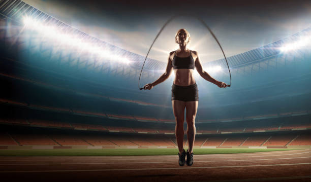 istock fit woman exercising with a jumping rope on a stadium 914940400