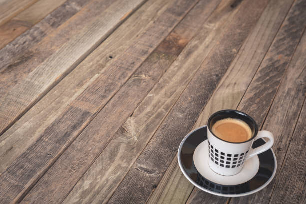 Single small espresso coffee cup on wooden background. Side view.