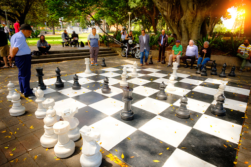 Senior friends playing chess in a city square