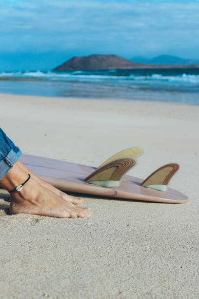 istock Surfer girl sitting on the beach 914949794