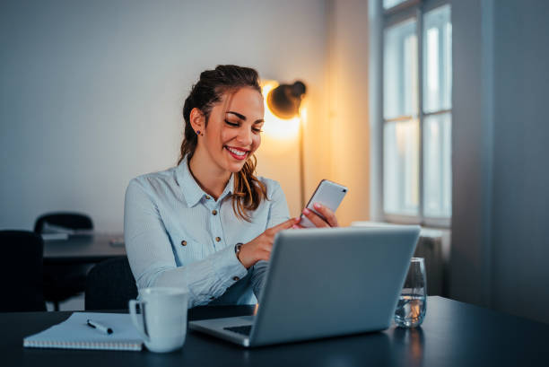 istock Young woman using phone in modern office. 914952582