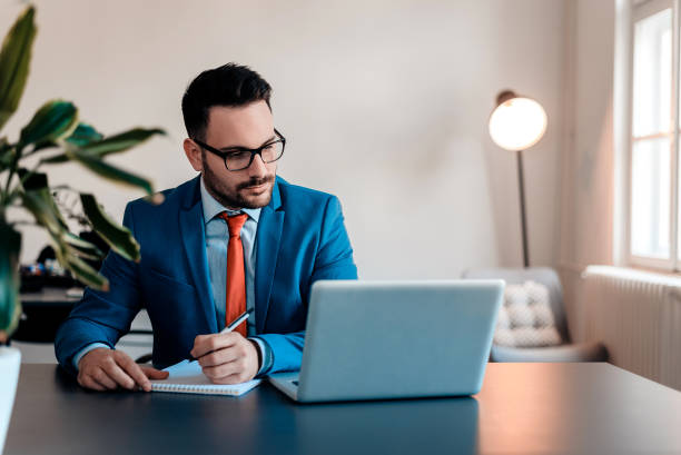 istock Young businessman working writing notes sitting in a desktop at office. 914952618