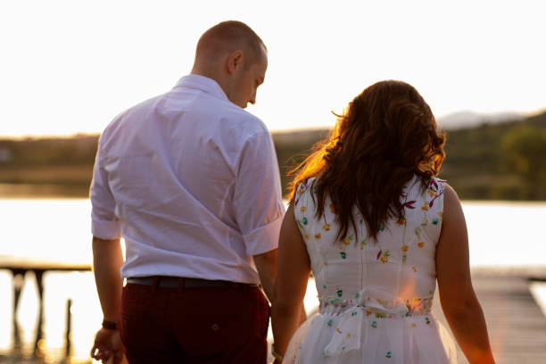 istock Romantic young couple on lake pier 914961286
