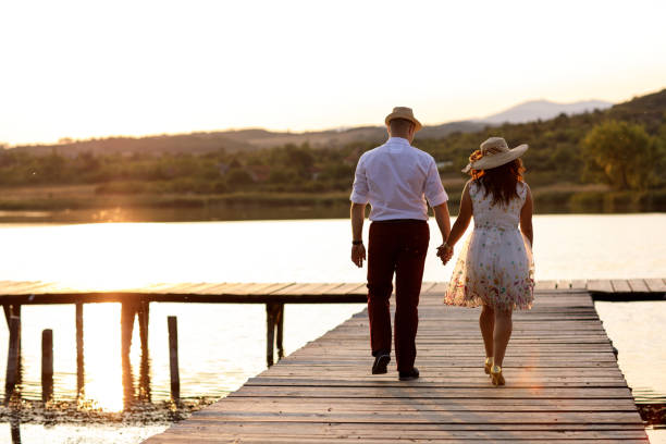 istock Romantic young couple on lake pier 914962352