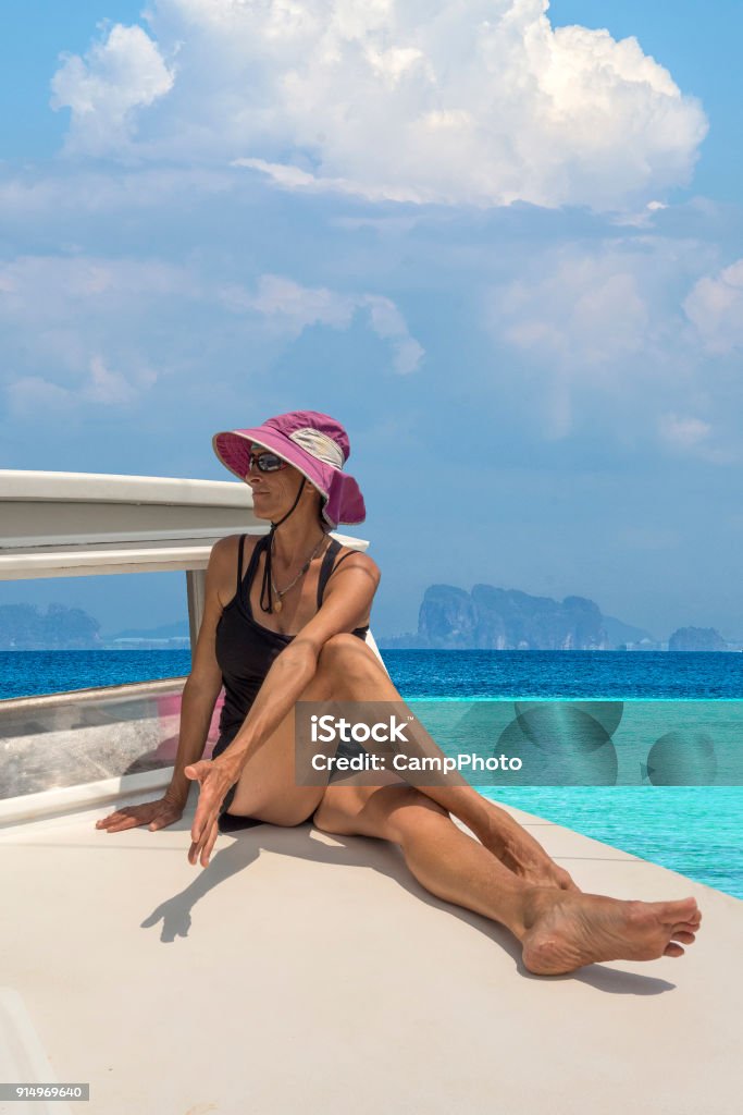 Water taxi yoga Stretching and practicing yoga on a boat in the Andaman Sea, Thailand. Southeast Asia. Adult Stock Photo