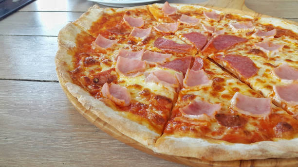 istock Hot pizza slice on wooden table 914973486