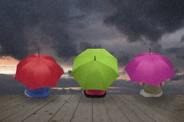 istock Three color umbrellas in the rain 914974640