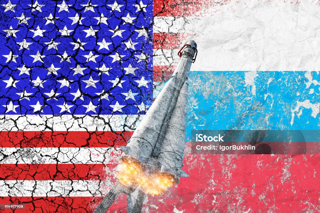 Confrontation between the USA and Russia. Threat of nuclear strike. The flags of two countries painted on the concrete wall. Arms race. Difficult relationship. Conflict between the United States of America and Russia. Cold war. Rocket launch. Tensions. Truce. Nuclear Weapon Stock Photo
