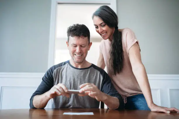 Photo of Mature Couple Photographing Check for Remote Deposit
