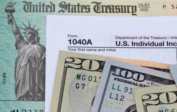 treasury check and currency with a 1040a tax return form - tax form treasury check tax imagens e fotografias de stock