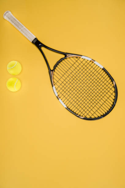 istock Tennis racket with balls isolated on yellow 914986536