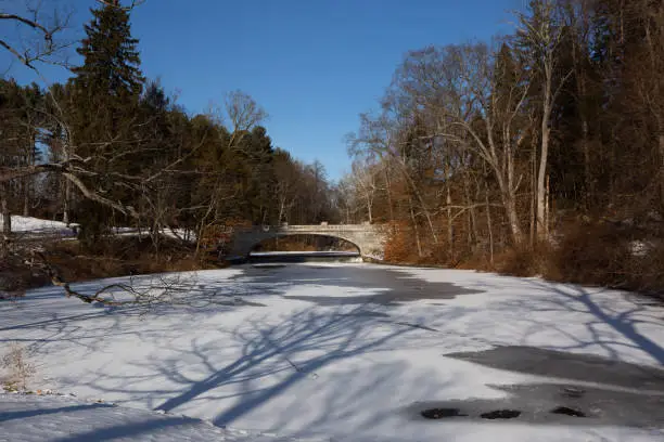 The frozen over Vanderbilt pond with a bridge i the background.
