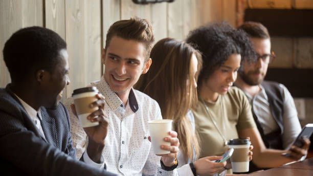 istock Multiracial men talking drinking coffee hanging with friends using gadgets 914989826