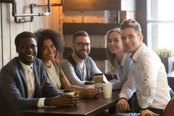 istock Multiracial friends group looking at camera sitting in cafe, portrait 914989828