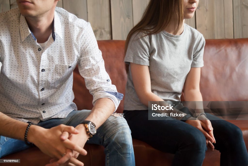 Frustrated unhappy couple sitting on sofa after fight, misunderstandings concept Frustrated unhappy young couple sitting on sofa after fight, disappointed boyfriend and offended girlfriend breaking up thinking of problems in bad relationships, misunderstandings and insult concept Couple - Relationship Stock Photo